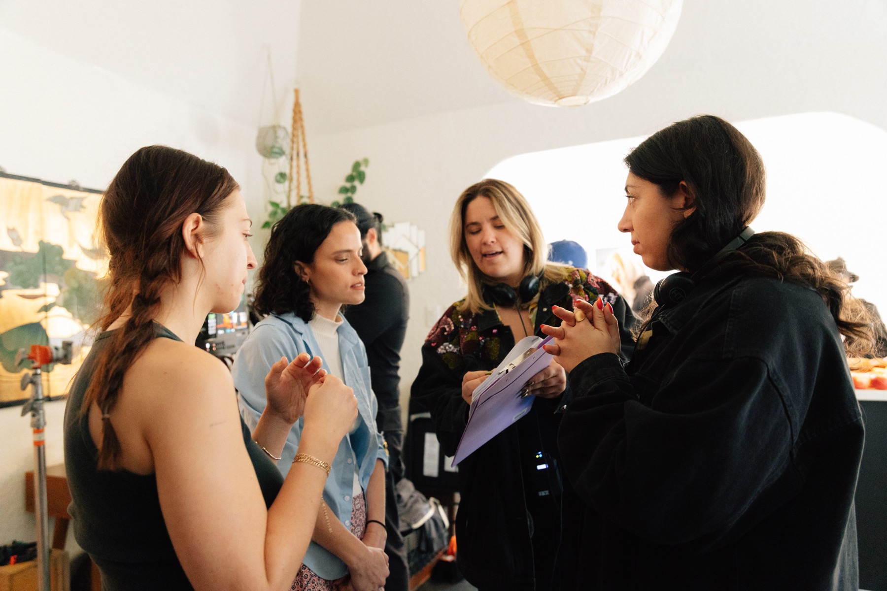 The cast and crew discussing a scene in a sunlit room