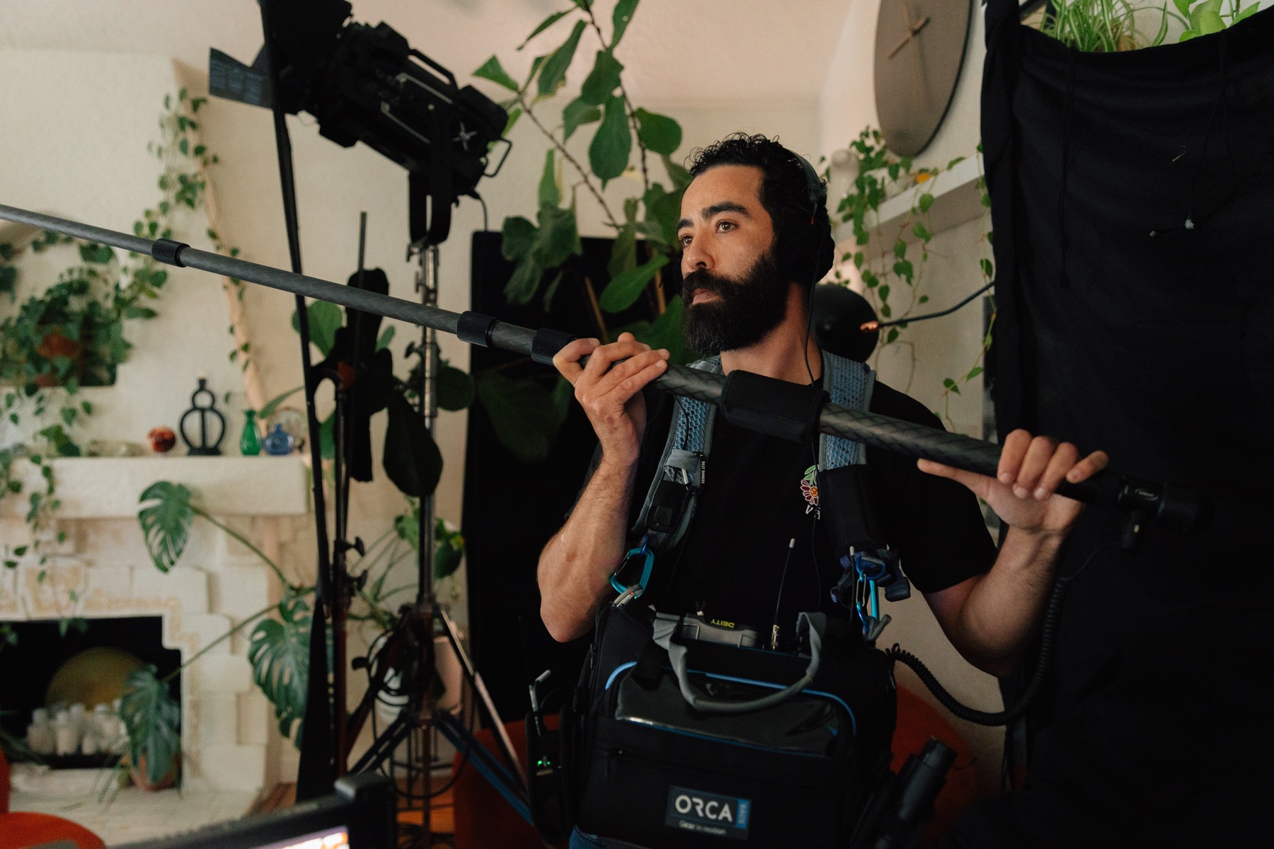 The sound recordist holding a boom microphone on set