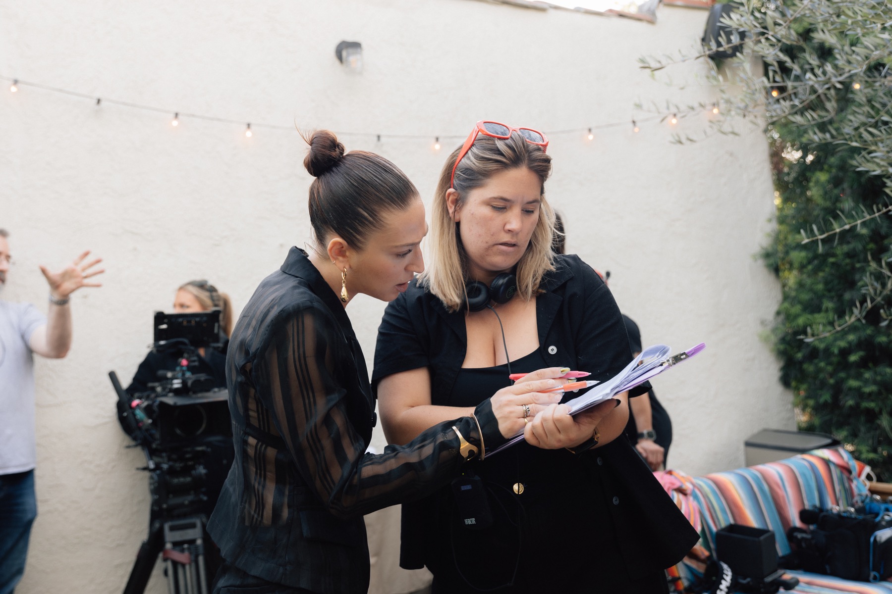 An actor and crew member reviewing notes outside